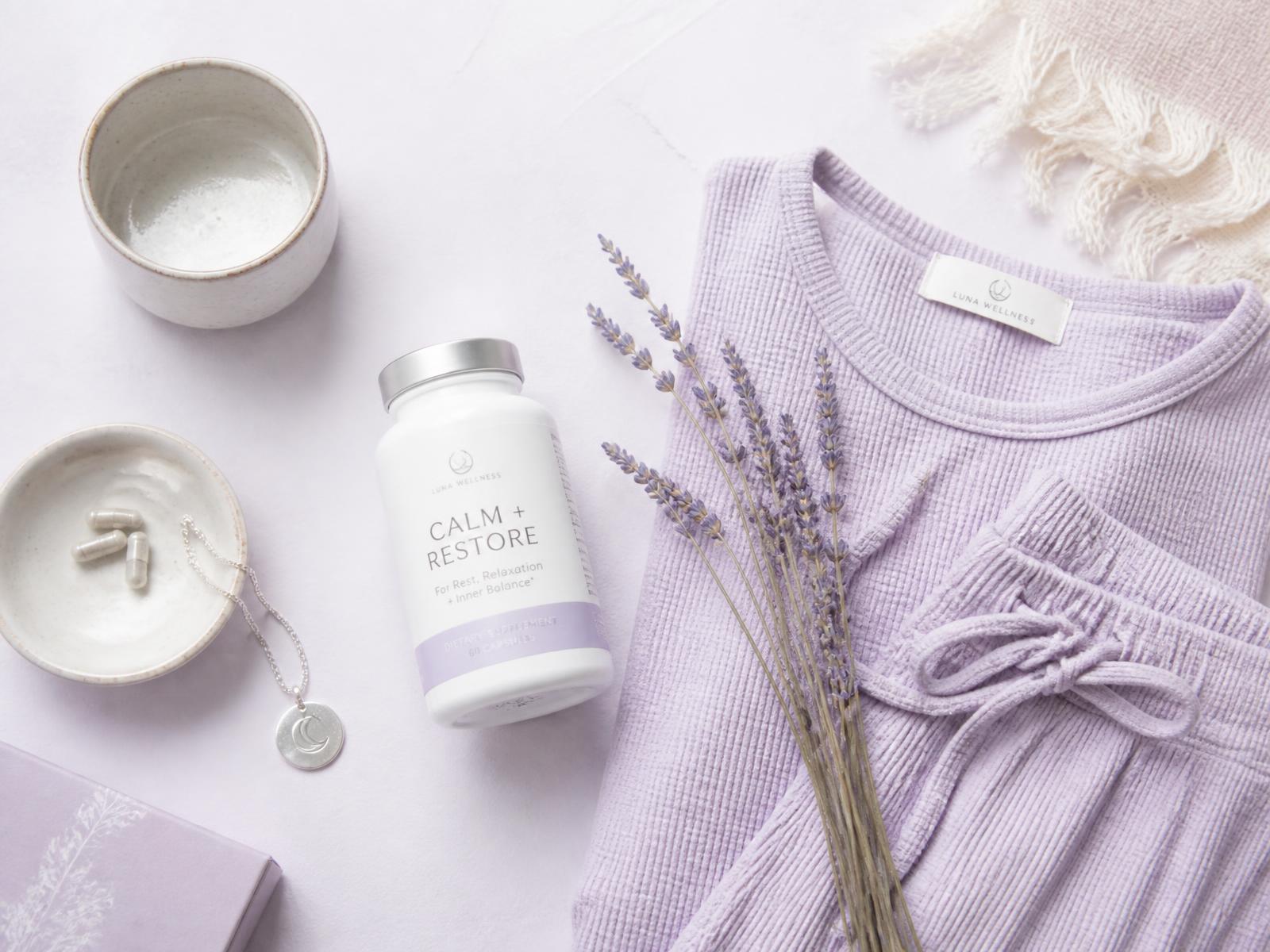 Lavender wellness flat-lay with supplements, loungewear and dried lavender